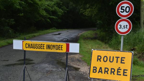 Route inondée barrée par un panneau de signalisation