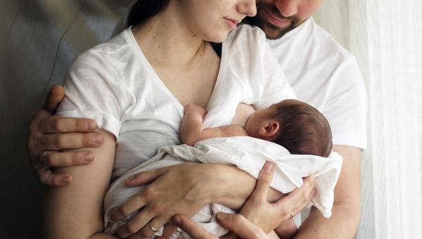 Allaitement de bébé avec papa enlaçant maman