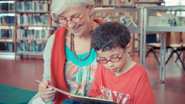 Enfant en train de lire avec une bénévole de Lire et faire lire