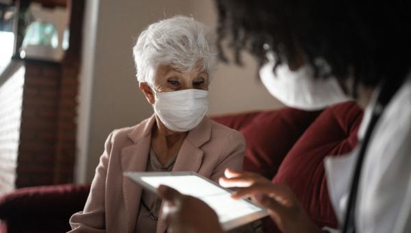 Une infirmière réalisant une préconsultation avant de se connecter à distance avec un médecin généraliste.