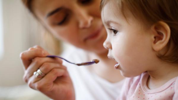 Assistante maternelle donnant son repas à un enfant