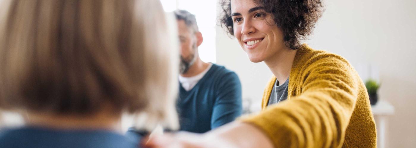 Jeune femme souriante mettant la main sur l'épaule d'une personne