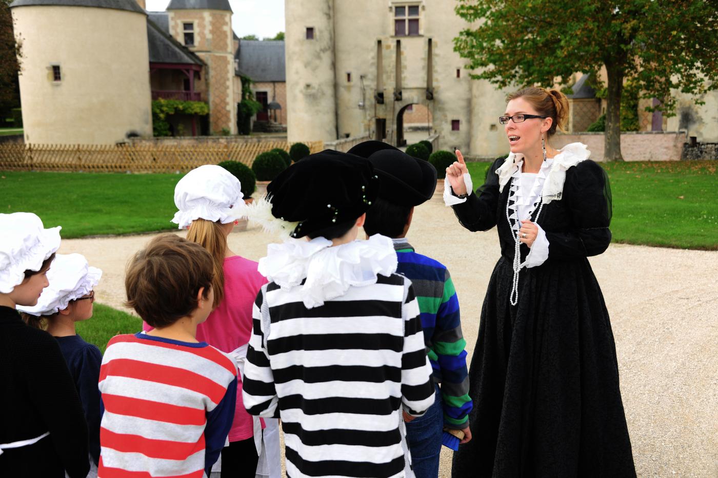 Groupes d'enfants costumés accompagné d'une guide en tenue d'époque devant le chateau de Chamerolles