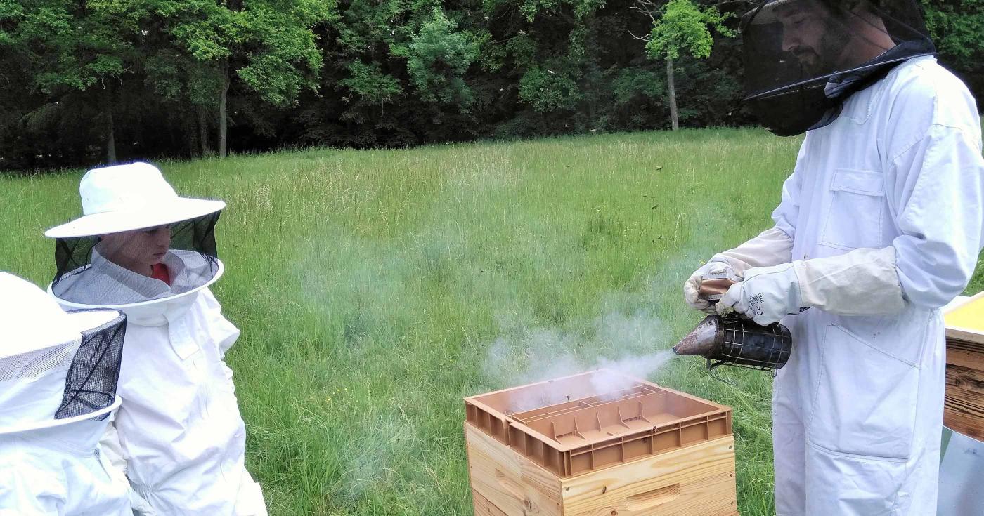 Des ruches à Chamerolles - 3 - atelier avec 2 enfants et l'apiculteur, chacun est vêtu d'une combinaison