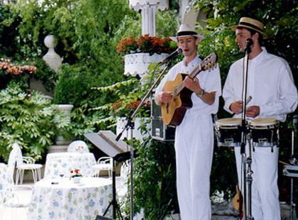 Deux homme vétu en blanc jouent de la musique sur une scène
