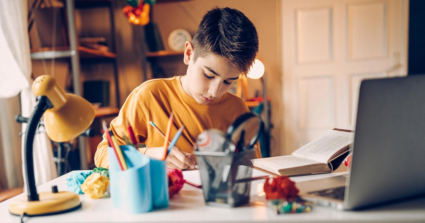 L'éducation au bout de la souris - garçon seul faisant ses devoirs devant son ordinateur