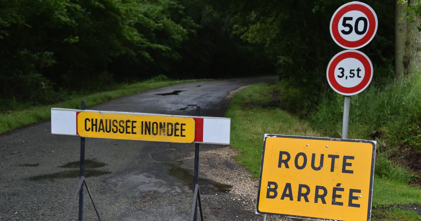 Route inondée barrée par un panneau de signalisation