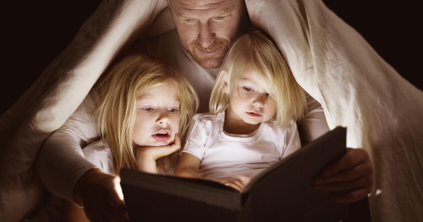 Papa lisant une histoire à ses deux fillettes