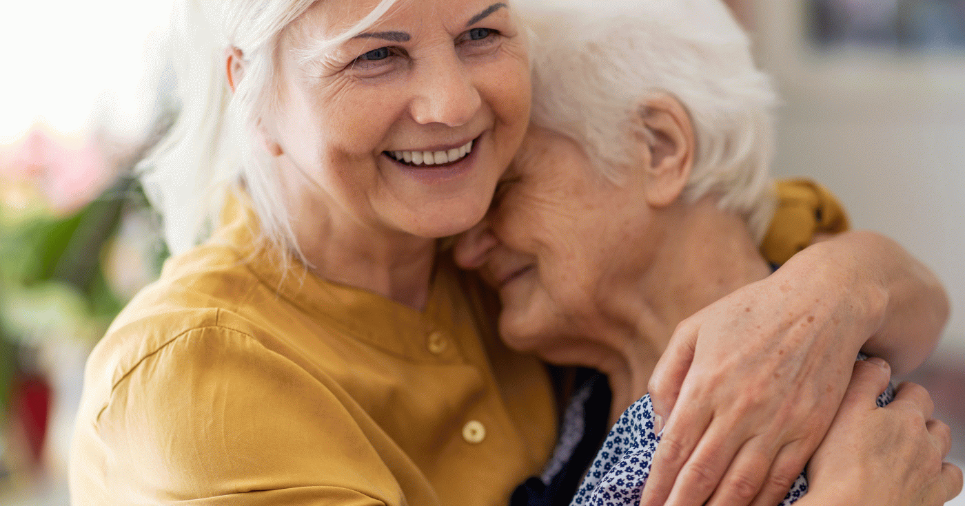 Femme entourant de ses bras une autre femme plus âgée