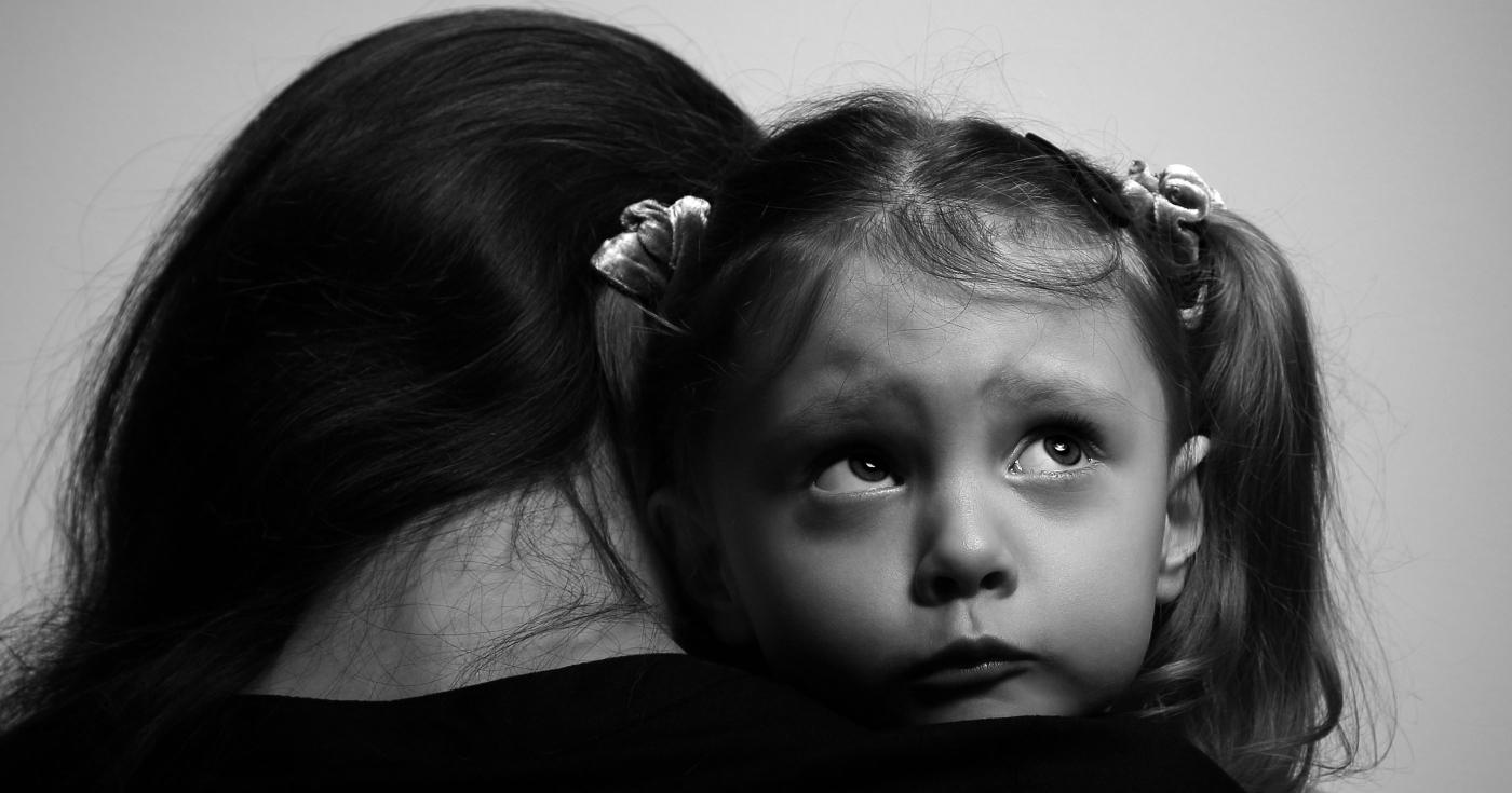 Une femme victime de violences familiales porte sa fille dans ses bras