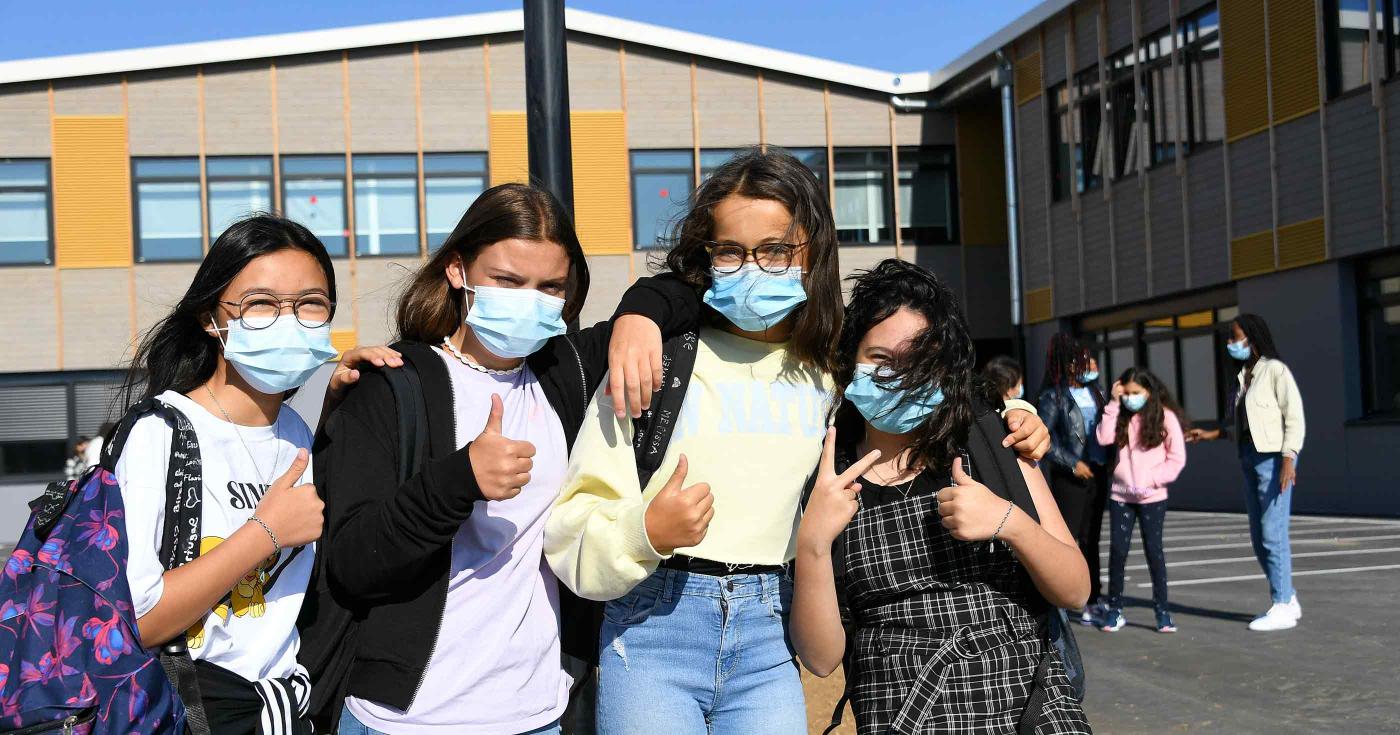 Groupe de quatre collégiennes dans la cour de leur collège