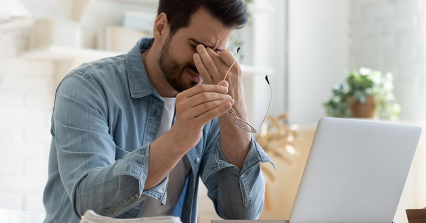 Moins d’écrans ? Un jeu d’enfant !? Homme ayant mal aux yeux devant un écran