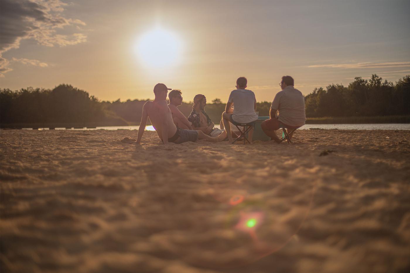 Photo de l'étang de la vallée avec des jeunes qui discutent sur la plage