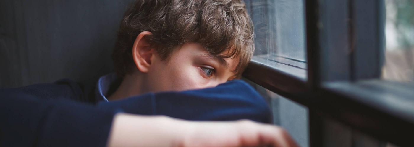 Enfant assis avec le regard dans le vide