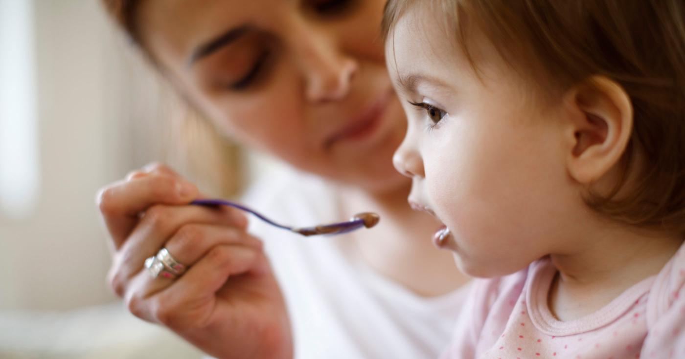 Assistante maternelle donnant son repas à un enfant