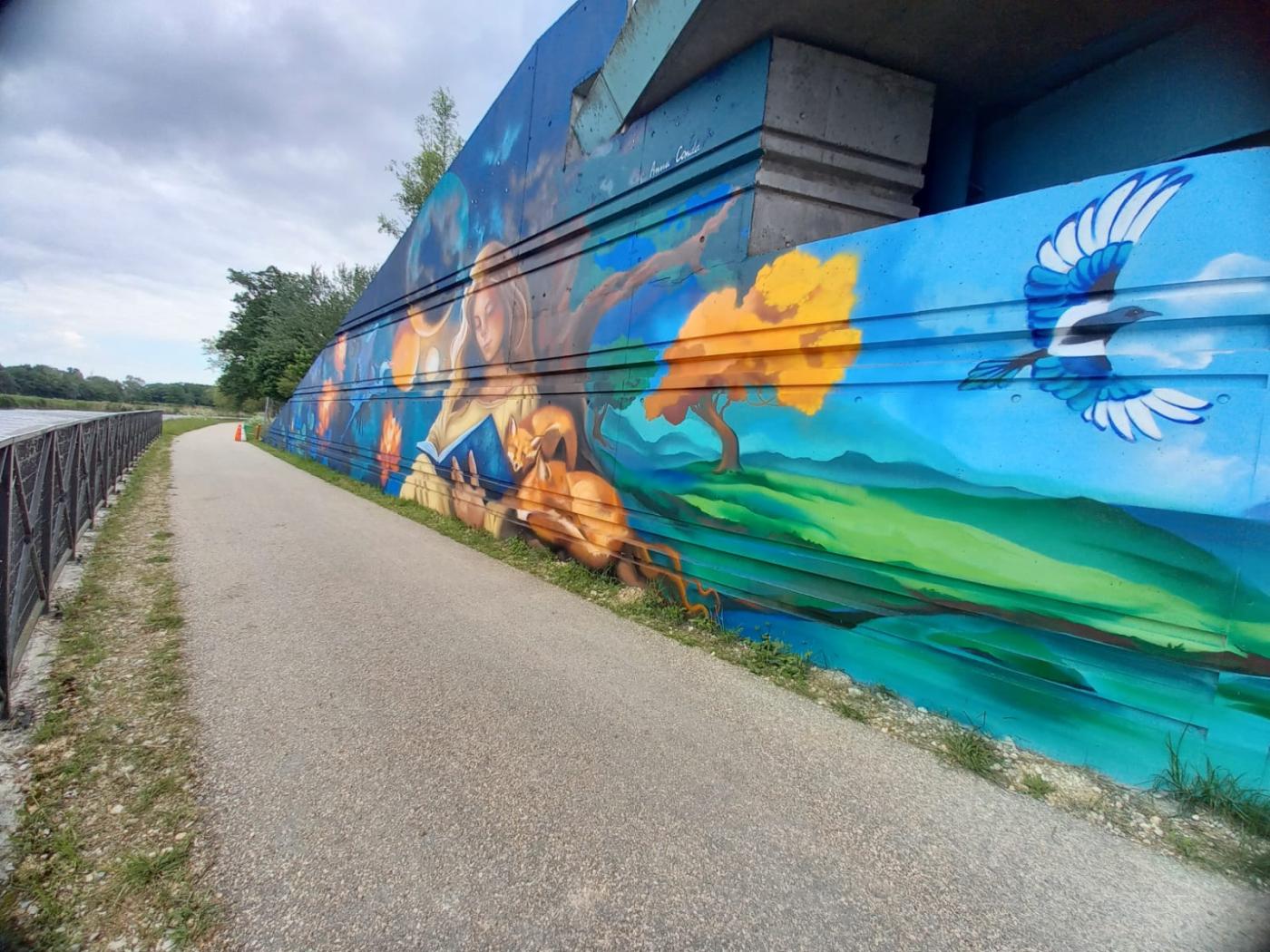 Peinture sous le pont de la RD2060 représentant une jeune fille qui lit en compagnie des deux renards et une pie qui s'envole.