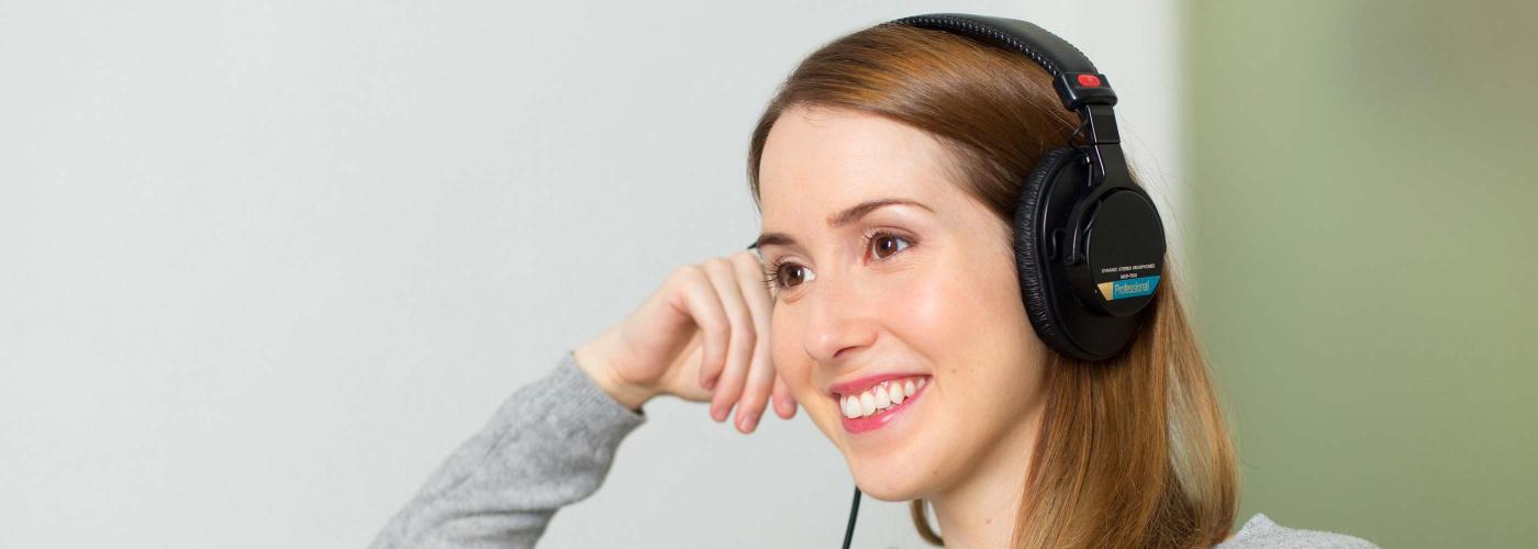 Femme souriante écoutant des sons avec un casque 