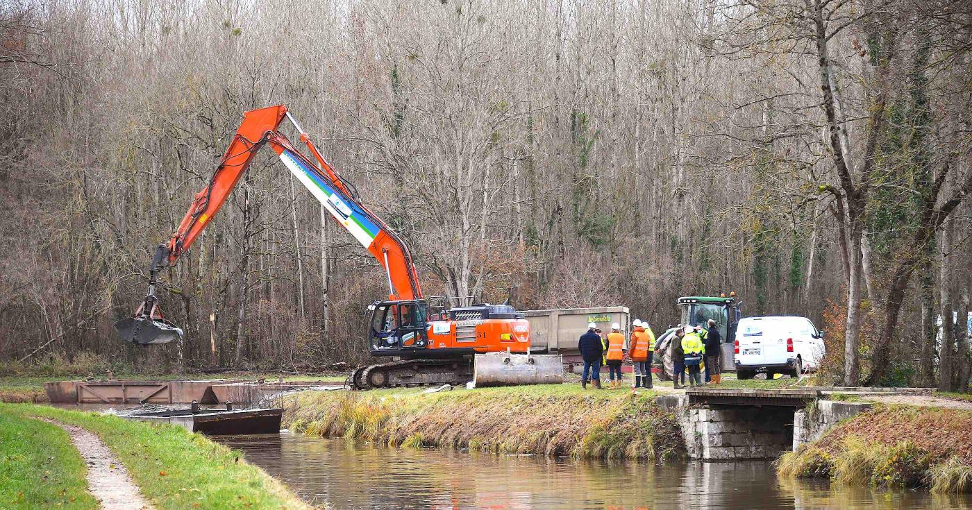 Pelle de travaux publics qui décharge une barge lors du curage du canal d'Orléans